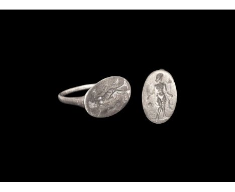 Greek Silver Ring with Standing Figure 5th-3rd centruy BC. A D-section hoop supporting an elliptical bezel with intaglio stan