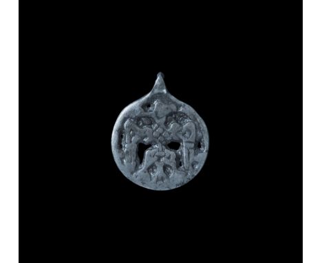 Viking Silver Pendant with Raven 11th century AD. A discoid pendant with loop, openwork design of a raven with spread wings w