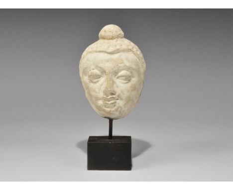 Gandharan Stucco Head of Buddha 2nd-4th century AD. A carved head of Buddha with soft features, heavy-lidded eyes, small purs