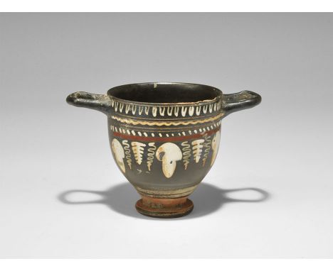 Greek Gnathian Ware Skyphos with Garland 5th-3rd century BC. A blackware skyphos with tiered foot and two square handles; to 