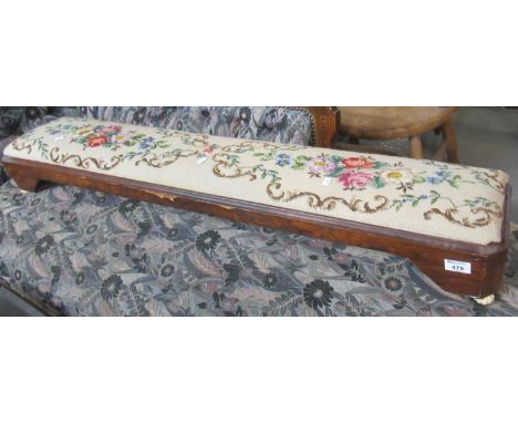 A Victorian walnut tapestry footstool of low rectangular form raised on ceramic fluted feet. 122cm long approx.  (B.P. 21% + 