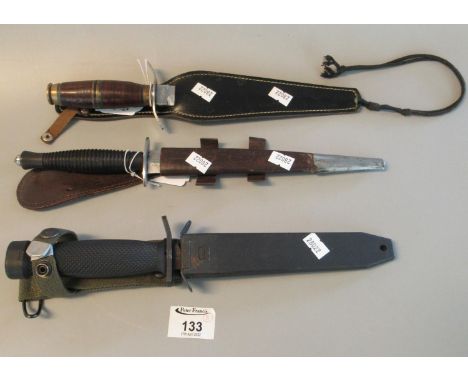 Three fighting knives, one appearing British military with metal scabbard ,Sykes Fairbairn design with leather scabbard and a