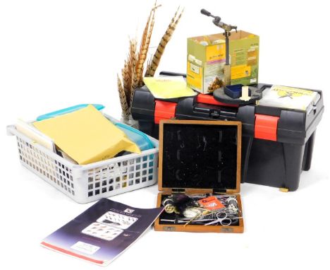 An assortment of fly tying equipment and materials, including a vice and collection of fly tying tools. 