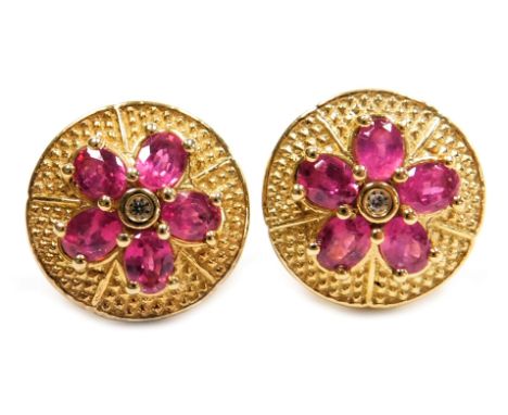 A pair of ruby and white stone set earrings, of five petalled flower head form, on a silver gilt circular mount, stamped 925.