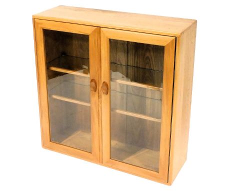An Ercol light elm display cabinet, with two glazed doors enclosing two shelves, 92cm high, 91cm wide, 30.5cm deep. 