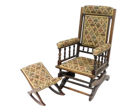 A Victorian oak American rocking chair, upholstered in floral tapestry fabric, 59cm wide, together with a footstool. (2)