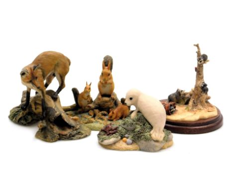 A Border Fine Arts sculpture of raccoons, another of a seal pup, a fox atop a tree bough, and a Chiltern sculpture of Family 