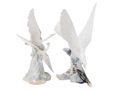 A Lladro porcelain figure of a dove, 29cm high, together with a Nao porcelain figure of two flying herons. (2) 