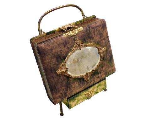 A Victorian portrait photograph album, with metal clasps, the front with a framed oval bevelled glass mirror, on a strut stan