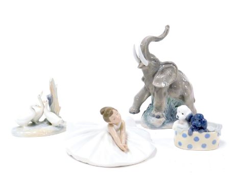 A Nao porcelain figure of a seated ballerina, figure group of three ducks, an elephant, and two puppies in a basket. (4)(AF)