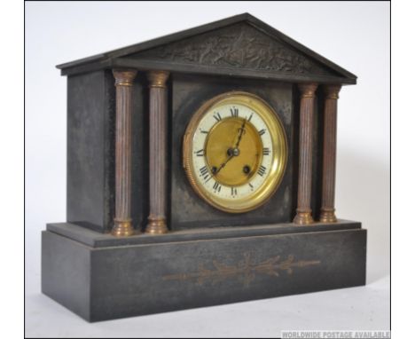 A 19th century marble / slate eight day mantle clock having double column supports with classical scene panels, an enamel fac