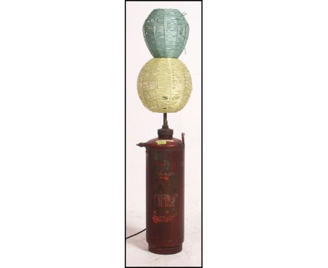 A stunning upcycled 20th century fire extinguisher having a retro conversion into a floor lamp fitted with a woven shade. Mea
