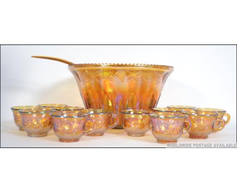 A vintage / retro 20th century Carnival glass punch bowl set to include the bowl cups and hooks along with the original ladle