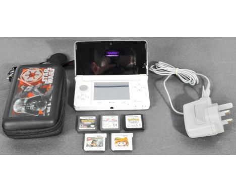 An original Nintendo made 3DS portable handheld video computer games console and games. The DS in white with 3DS Super Mario 