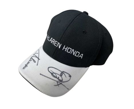 A McLaren-Honda F1 baseball cap, bearing the signatures of Jensen Button and Fernando Alonso in black ink.