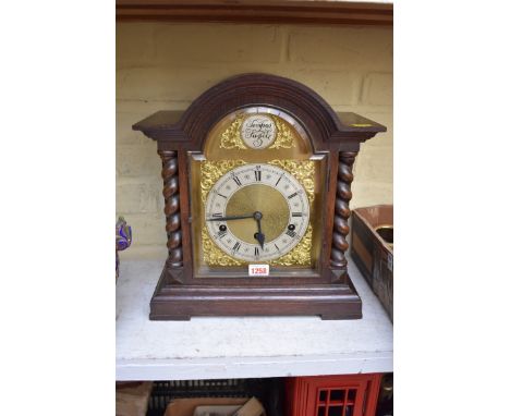 A 1920s oak mantel clock, 37.5cm high, with pendulum.&nbsp; 