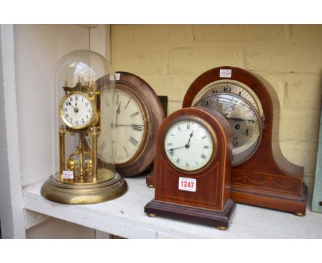 An brass anniversary clock, with glass dome; together with another Edwardian mahogany and inlaid mantel clock; and two other 