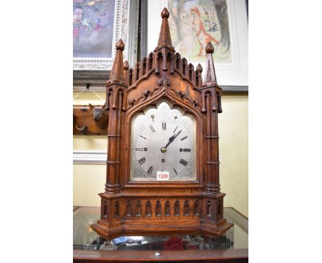 A Victorian Gothic carved oak musical bracket clock, with silvered dial and triple fusee movement, 65cm high with pendulum an