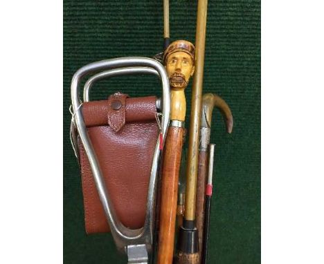 A bundle of walking sticks, shooting stick, show horn, fishing rod etc 