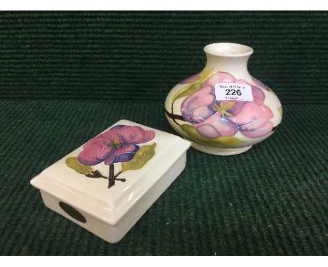 A Moorcroft white magnolia squat vase with pink and purple flowers, together with a matching lidded trinket box (2)