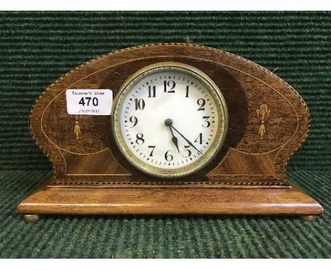 An inlaid oak mantel clock on brass feet 