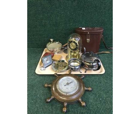 A tray of desk and travel clocks, clock under shade, ships wheel barometer, plated ware, binoculars etc 