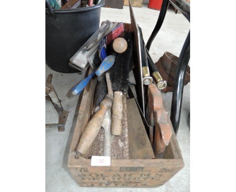 A wooden box containing various workshop tools 