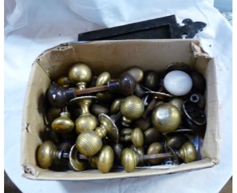 A box containing a quantity of old brass, ceramic and Bakelite doorknobs and a cast iron letter box