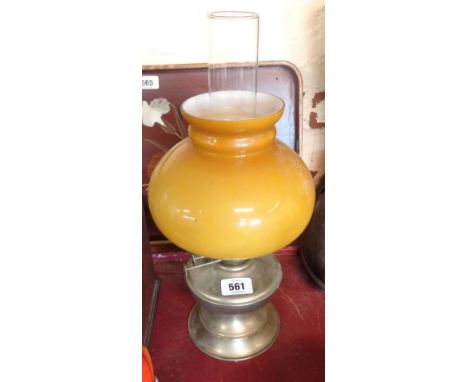 A vintage oil lamp with goblet form base and reservoir, a yellow opaque shade and a chimney