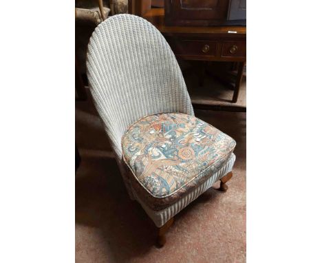 A pair of vintage Lloyd Loom style nursing chairs with original white sprayed finish and sprung seats