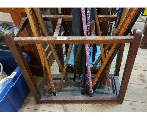 A vintage oak stick stand with metal drip tray