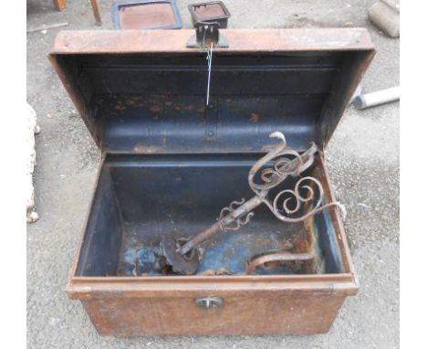 An old tin trunk containing a pair of wrought iron candlesticks