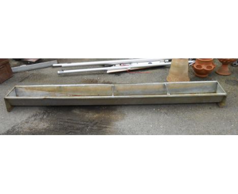 A large vintage metal animal feed trough