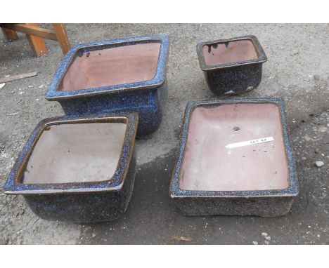 Four graduated black glazed ceramic garden pots