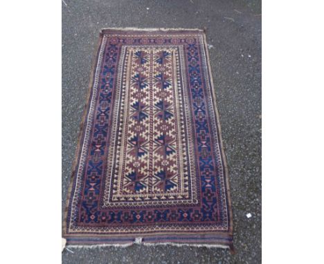 A vintage handmade wool rug with geometric repeat motifs within a wide border on grape coloured ground - 1.6m X 92cm