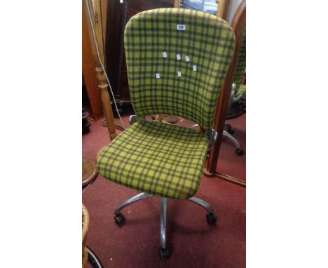 A vintage style swivel office chair with green tartan upholstery, set on a chrome plated five star base with casters