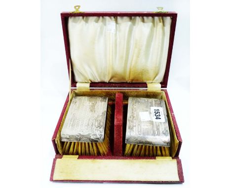 A cased pair of vintage silver backed brushes with engine turned decoration and engraved initials 'W.R.H' - Birmingham 1964
