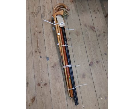 Seven walking stick of various form including brass bird head topped examples, hatchet top form, etc. - sold with a snooker c