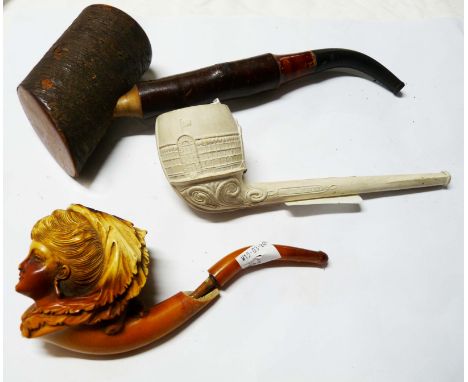 A bag containing three pipes comprising a Meerschaum example (a/f), a clay pipe with the Crystal Palace decorated onto the bo
