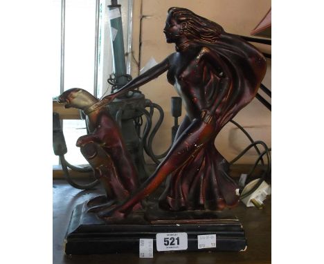 A vintage Art Deco plaster figurine of a lady holding back a leaping animal with a copper painted finish