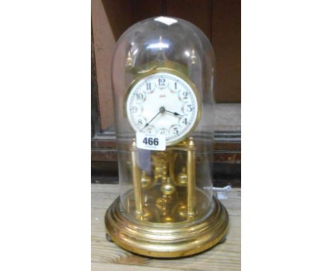 A vintage Kundo brass anniversary clock with ball pendulum, under glass dome