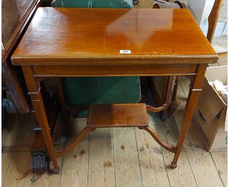 A 71cm Edwardian mahogany, crossbanded and strung fold-over card table with raised shaped undertier, set on square tapered su