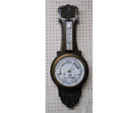 A late Victorian carved oak framed banjo barometer/thermometer with printed ceramic dial and aneroid works
