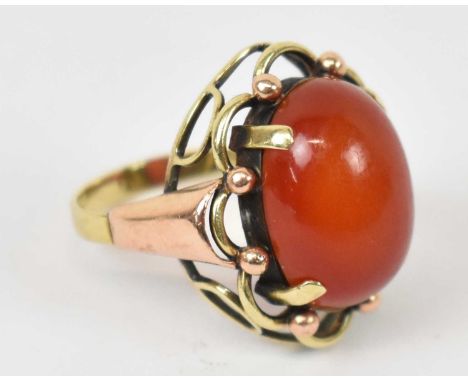 A 14ct yellow gold ring with central red stone, size N, approx 5.8g.