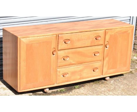 ERCOL; a mid century light oak sideboard with three central drawers flanked by cupboard doors, length 156cm, height 70cm and 