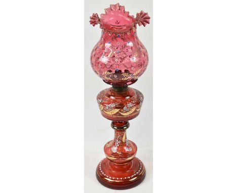 A Victorian ruby glass oil lamp with painted decoration, height 54cm.