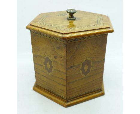 A hexagonal oak tea caddy with lid, marked 1918 
