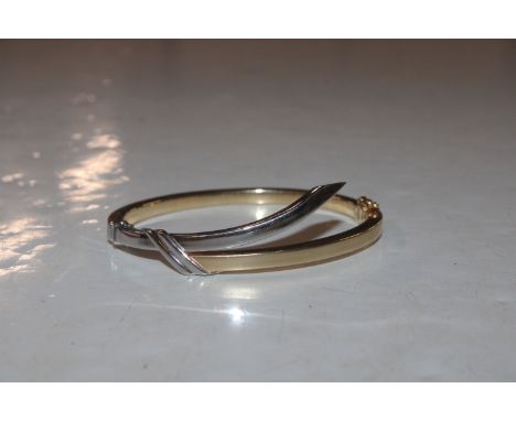 A yellow metal and white metal bangle, marked 585, approx. 14.5gms 
