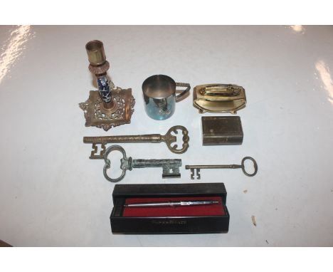 A box containing a Papermate pen, a blue and white porcelain mounted candlestick, a Ronson table lighter, decorative keys etc