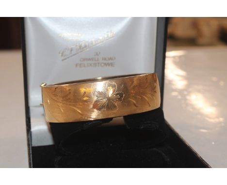 A yellow metal snap bangle, marked 750 approx. 34gms 